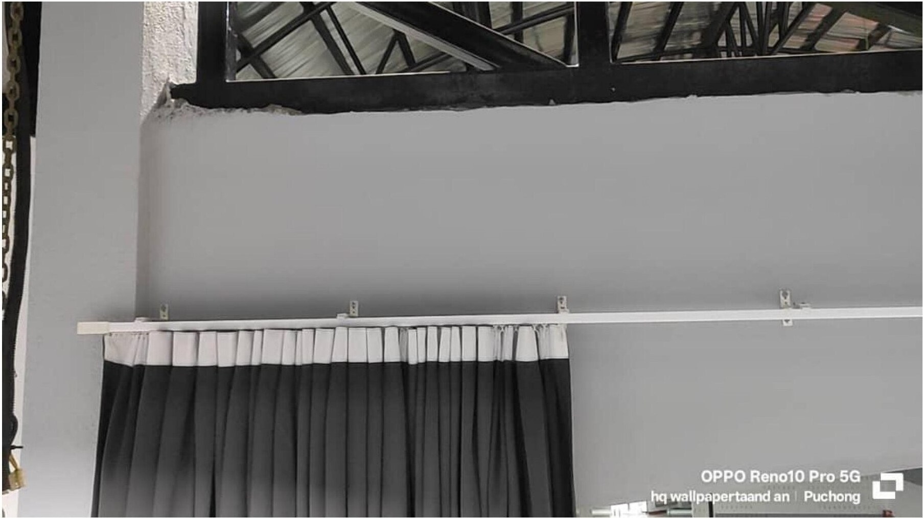 Black pleated stage curtain on white track, close detail